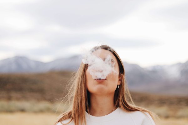 Woman surrounded by smoke outdoors, representing anti-pollution skincare