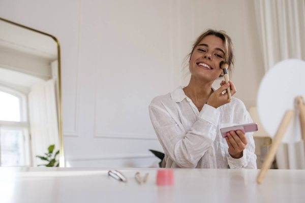 Woman applying complexion makeup, comparing BB cream, CC cream and foundation