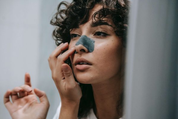 Woman using a pore strip, illustrating common skin imperfections and how to reduce them