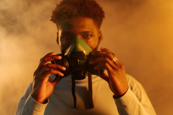 Black guy with a gas mask on surrounded by smoke