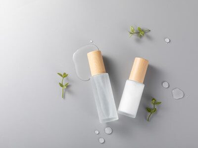 top-view-skincare-bottles-surface-with-green-plants1 (1)